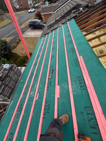 Green breathable membrane and battens on another slope, loft insulation visible
