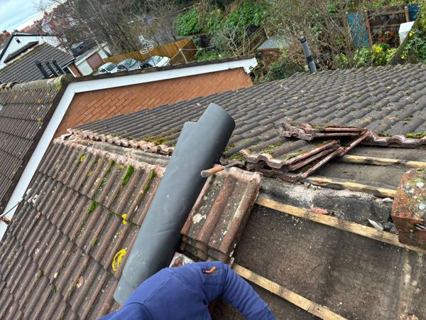 Grey dry ridge roll laid out beside stripped battens and stacked tiles