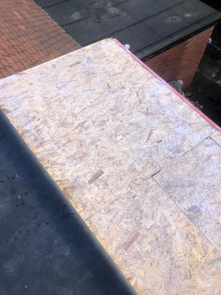 New OSB deck boards laid beside a section already finished in rubber