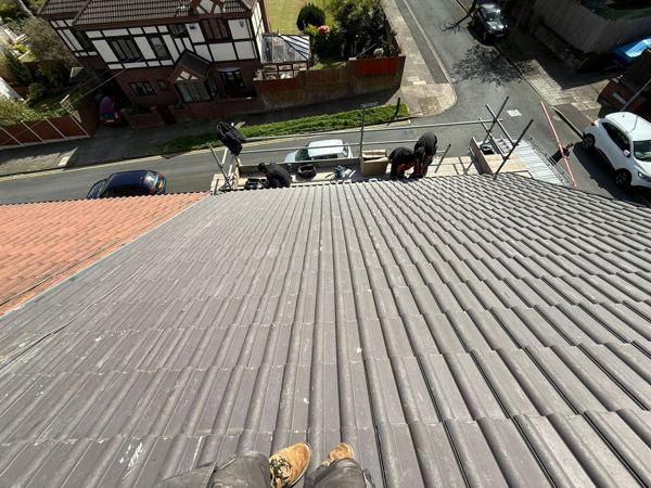 Tiling from the scaffold, with a guard rail along the eaves