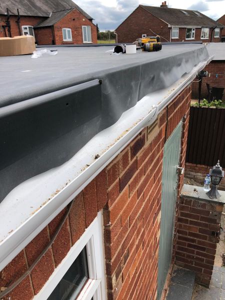 Rubber dressed into the edge trim above the new white gutter