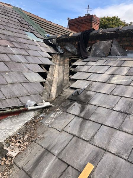 Slates stripped either side, exposing the old valley boards below the chimney