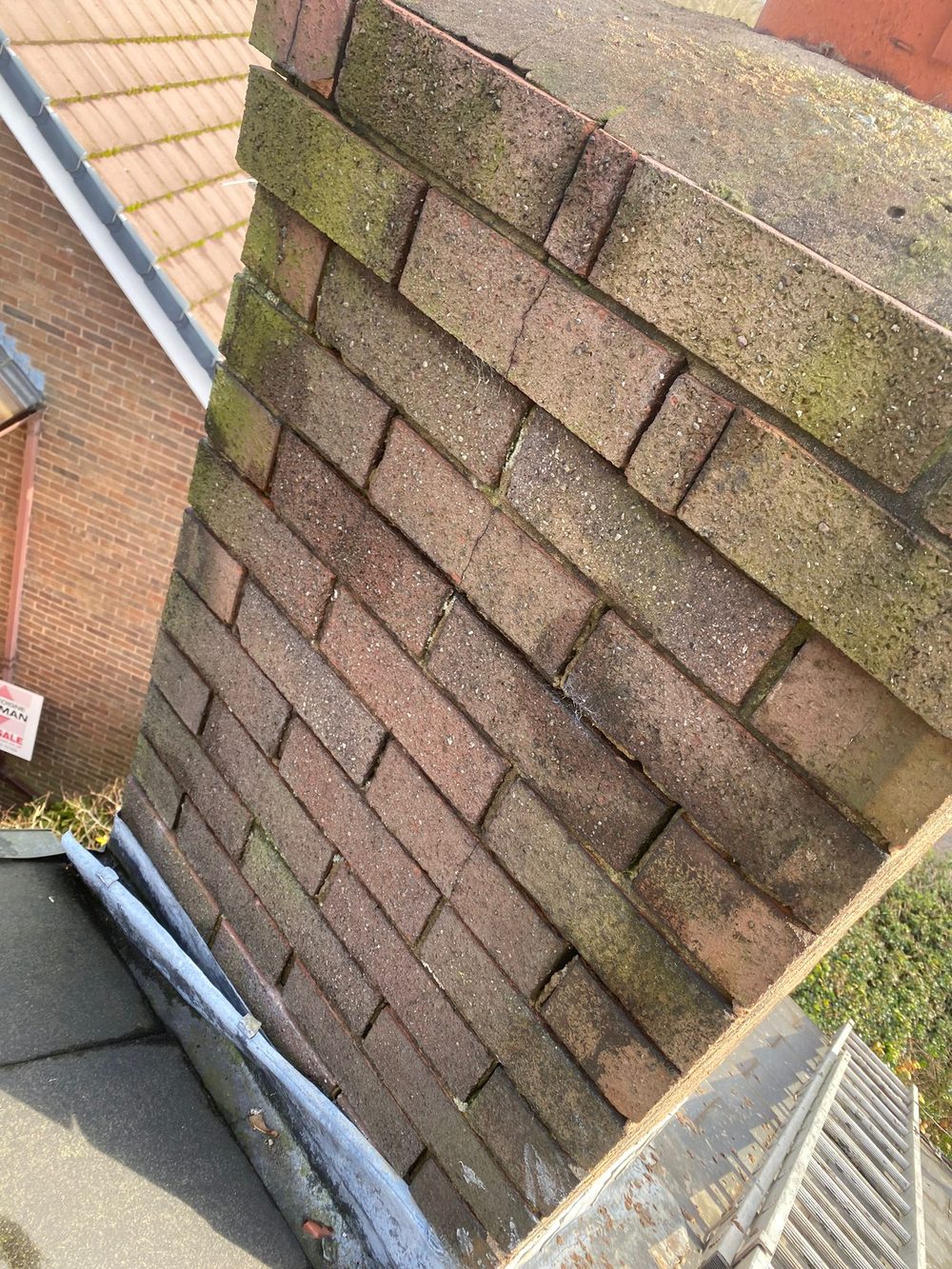 A close view of eroded bedding and open vertical joints on the weather face of a brick stack