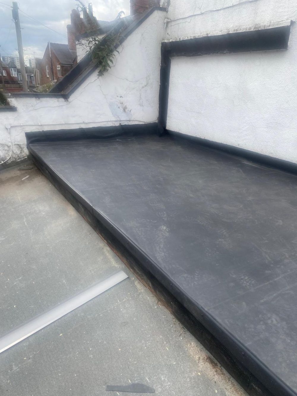 A finished EPDM roof on two levels, taken up as an upstand against the rendered wall