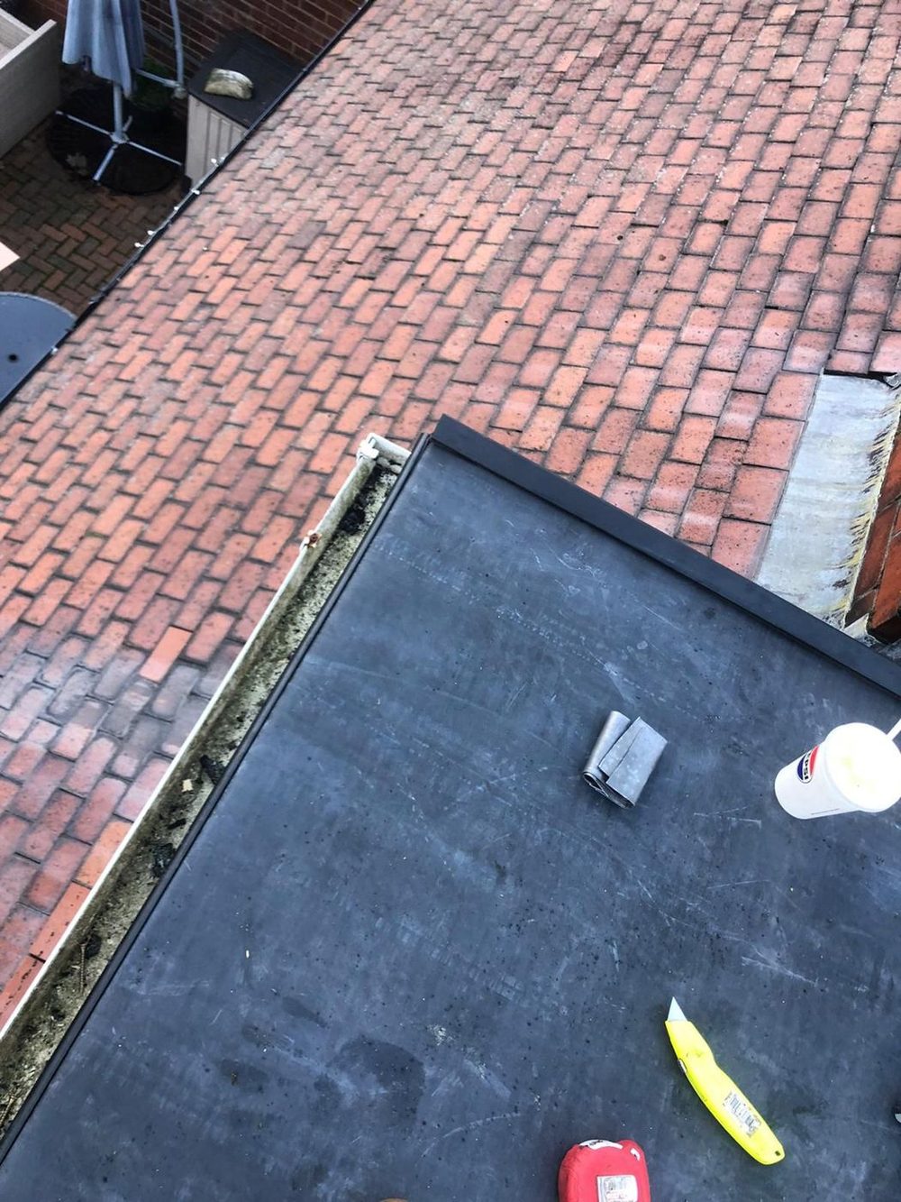 EPDM finished up against a tiled pitched slope, with the trim run along the open edge