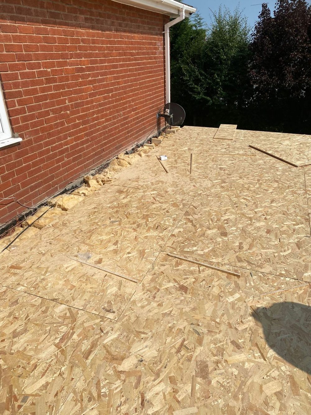 A new deck run right out to the edge, the gap along the house wall packed out before the covering goes on
